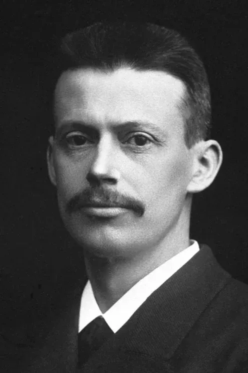 黑白肖像照:芬森(Niels Ryberg Finsen),中年男性,短髮往後梳、留著八字鬍,穿深色西裝與白色立領襯衫,臉微微向右、眼睛看向鏡頭,背景全黑。