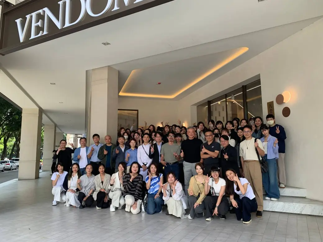 診所門口的大合照，醫師與同仁站滿整個騎樓，上方是 VENDÔME 的招牌。