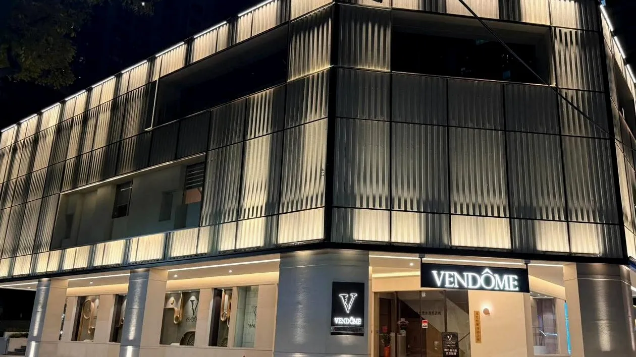 台中 VSKIN 凡登皮膚科診所的夜間外觀，直紋玻璃立面打光，一樓入口有 VENDÔME 招牌