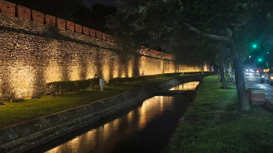 雨後的左營舊城東門護城河，夜燈落進水裡，把城牆的倒影收了進去。